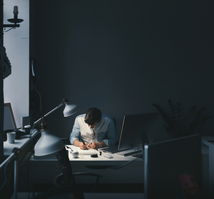 Designer at work in office. Man drawing in note pad